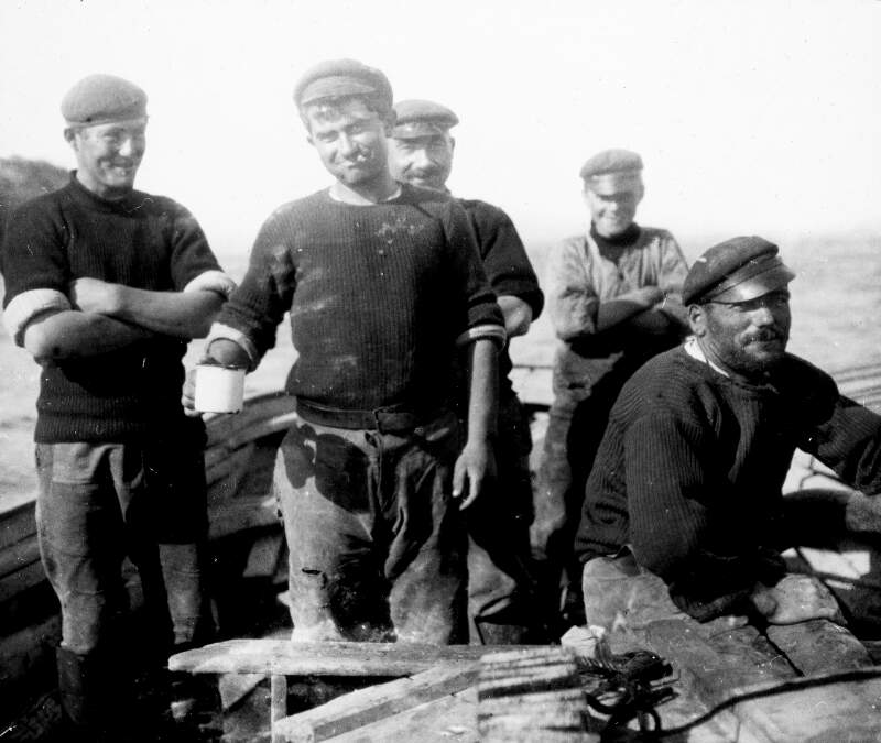 'View of French lobster boat', five men wearing traditional caps on board.
