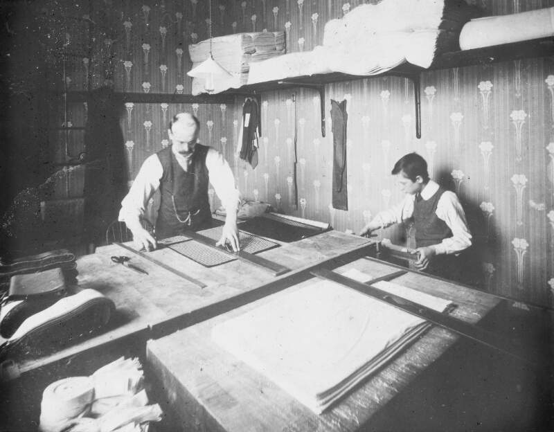 Atkinsons Poplin Factory. Two male workers at table, measuring.