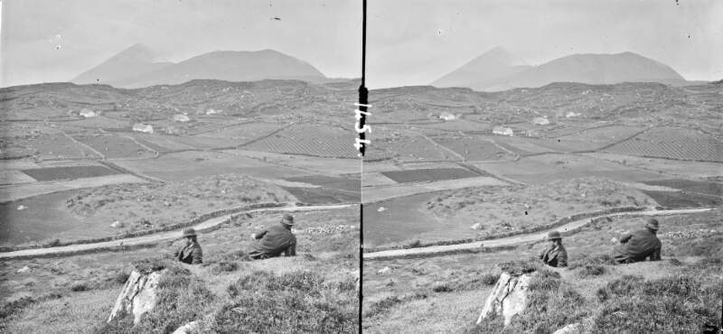 High angle, landscape of fields with stone walls, Croagh Patrick in background, 2 men reclining in foreground, Croagh Patrick, Co. Mayo