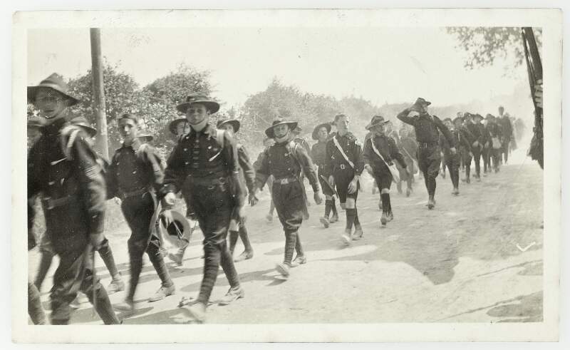 [Children in uniform marching along country road, presumably as part of Fianna Éireann]