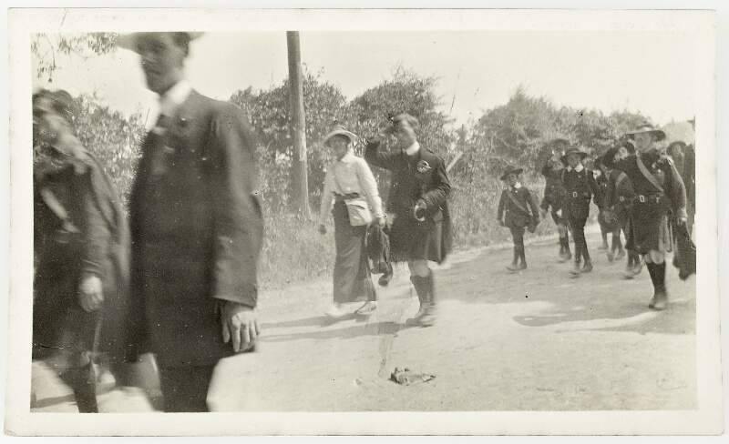 [Unidentified children marching along county road, including man and woman [Countess Markievicz?] marching in front of children]