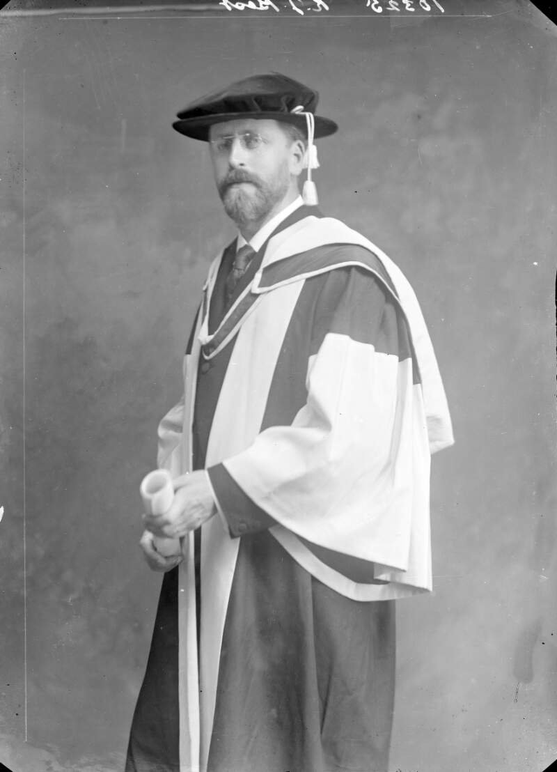 [R.J. Best, in graduation gown and cap, holding scroll, three-quarter length portrait, facing left.]