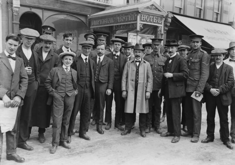 [Survivors of the Lusitania disaster, Co. Cork : group of men and crew in uniform, standing outside the 'Imperial Hotel']