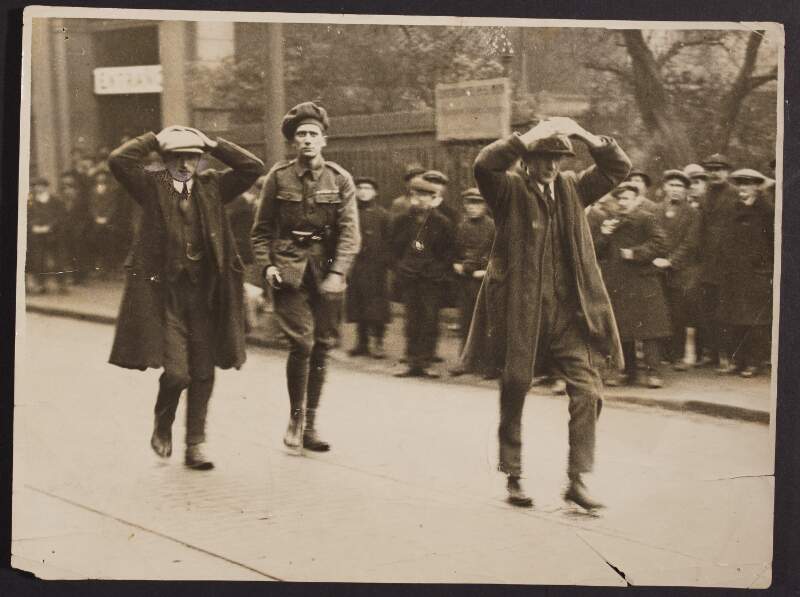 An Auxiliary with two civilians captured during a Raid on the "on the Run" Ministry of Labour Office. March 1921.