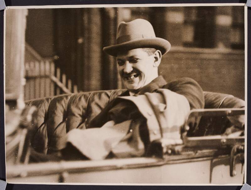 [Close-up of Michael Collins laughing in a car]