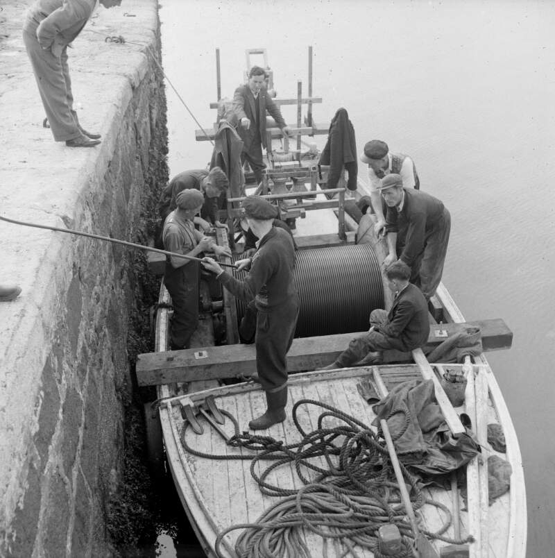 [Men in fishing boat laying a submarine cable to Arranmore Island, Co. Donegal]