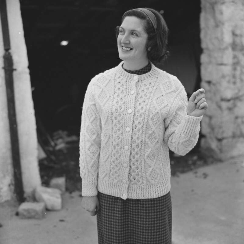 [Female modelling garments for Dungloe Co-op knitting, Co. Donegal]