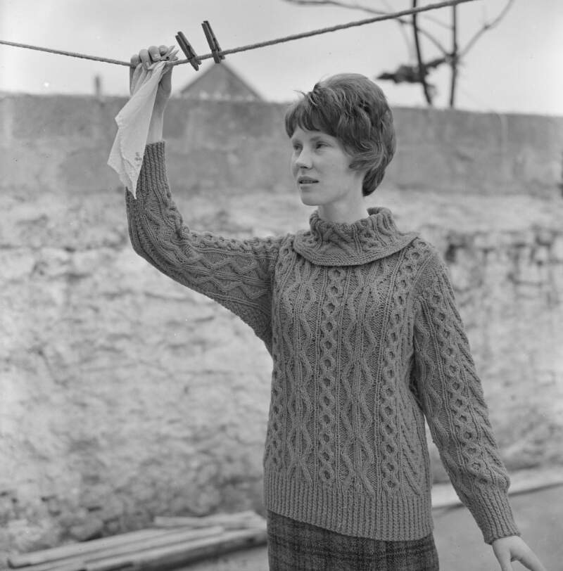 [Female modelling garments, with washing line, for Dungloe Co-op knitting, Co. Donegal]