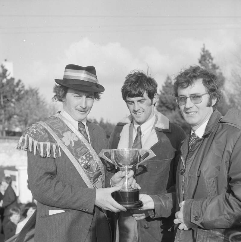 [Man presenting trophy to another man at the Easter Parade in Dungloe, Co. Donegal]