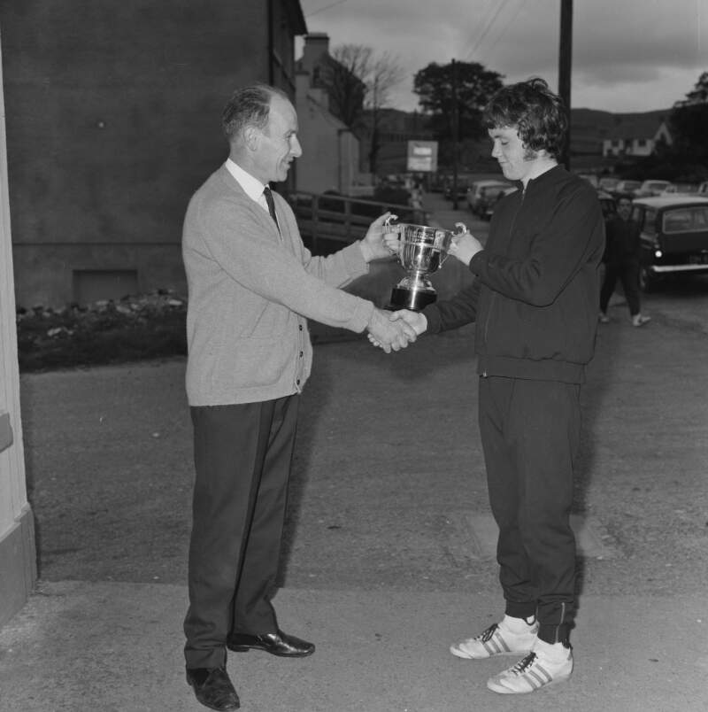 [Male competitor receiving trophy after road race, Glenties, Co. Donegal]