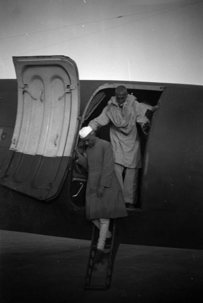 [Jawaharlal Nehru disembarking from an airplane, followed by unidentified man]