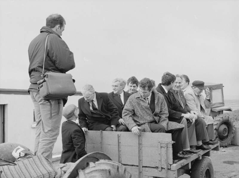 [People sitting on trailer attached to a tractor on Tory Island, Co. Donegal]