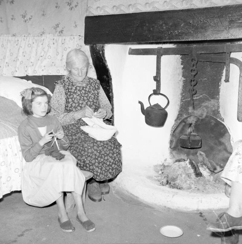 [Women knitting by fire place in cottage, Lettermacaward, Co. Donegal]