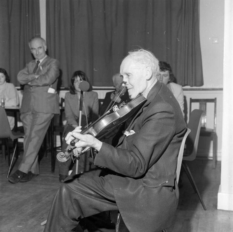 [John Doherty playing the fiddle in function room, Co. Donegal]