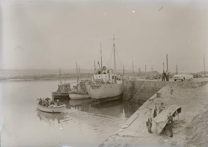 [Men working on fishing boats in harbour, Co. Donegal]