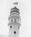 [Completed lighthouse, with keeper looking out through telescope at Fastnet Rock, off the coast of Co. Cork]
