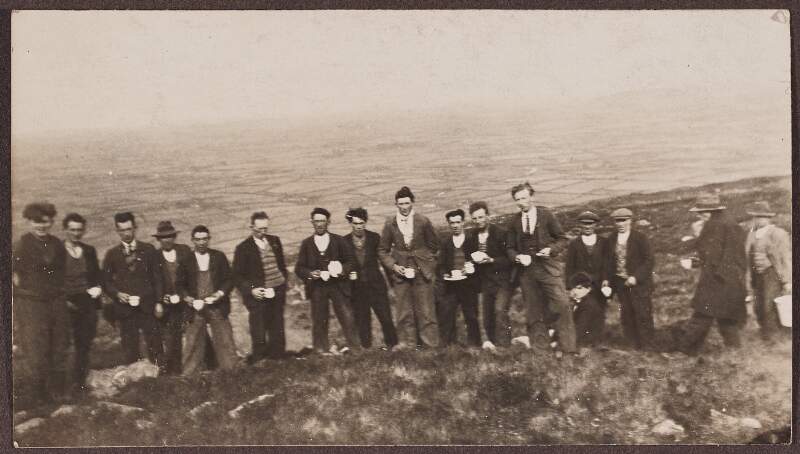 [Group of men on a hillside, drinking cups of tea]