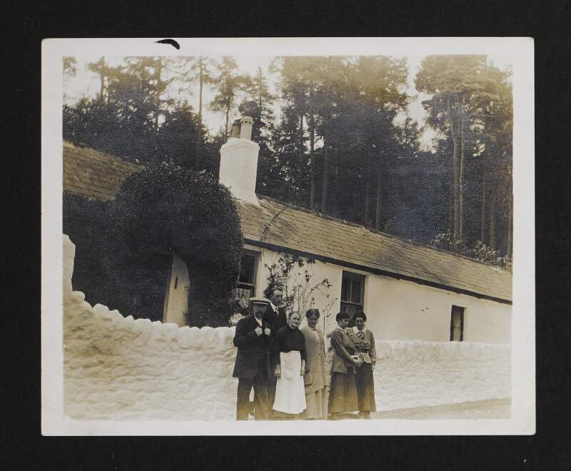 [Six unidentified people standing outside a house]