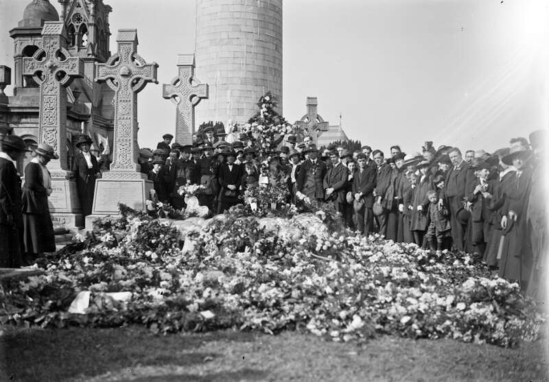 [Funeral of O'Donovan Rossa, graveside in Glasnevin Cemetery, grave covered with flowers, crowds]