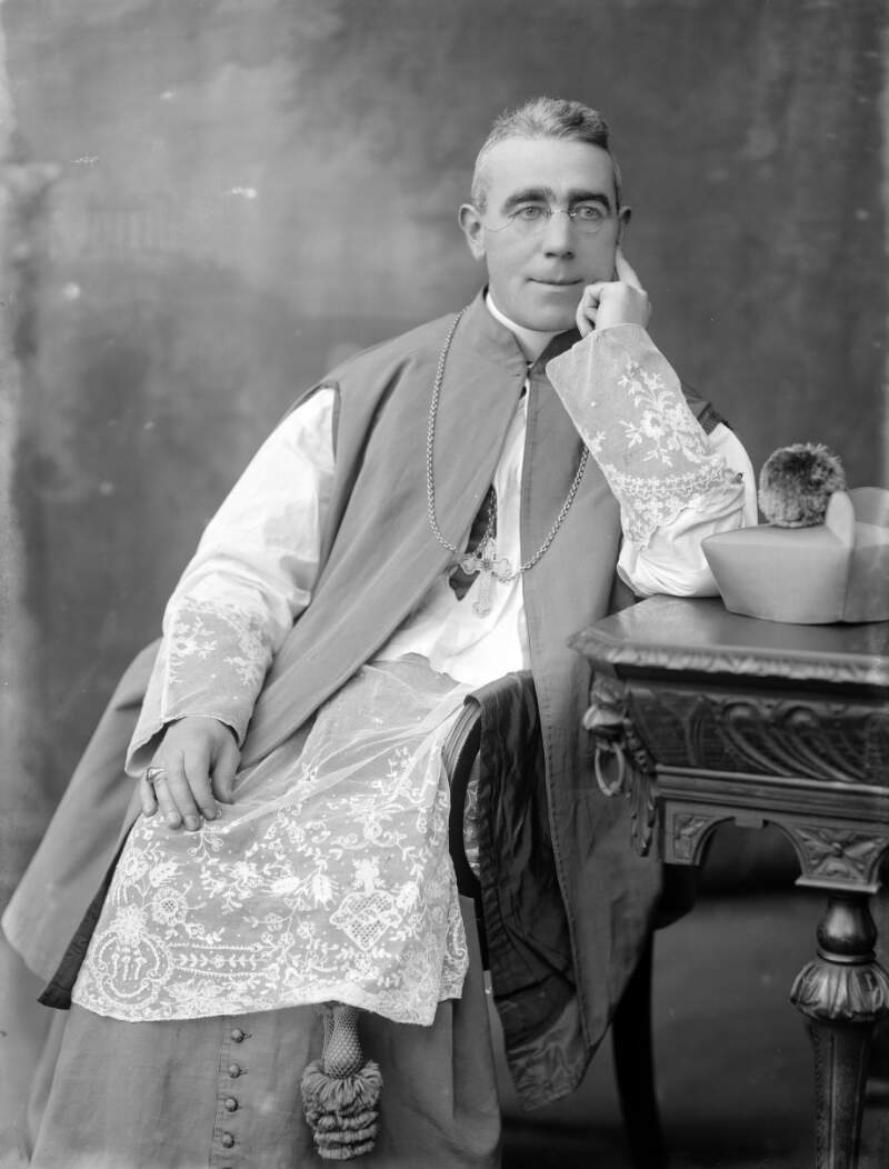 [Most Rev. William Mac Neely seated by table, three-quarter length portrait]