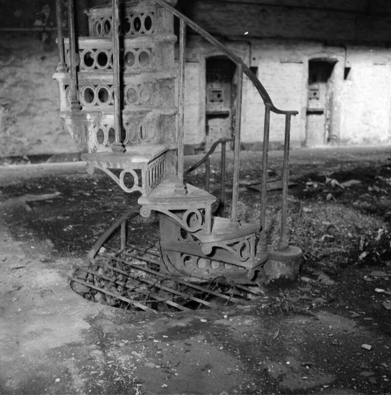 [Spiral staircase in disrepair, Kilmainham Gaol, Dublin]