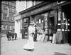 [Woman walking past stationery shop, O'Connell Street]