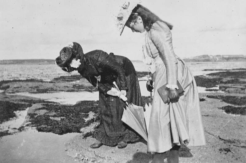 [Woman and girl looking at a rockpool, possibly at Laytown strand]