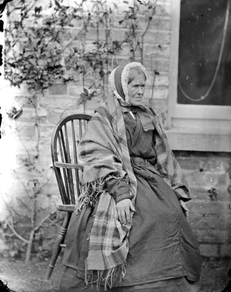 [Portrait of elderly woman, possibly servant, seated outside the photograph house, Clonbrock, Co.Galway]