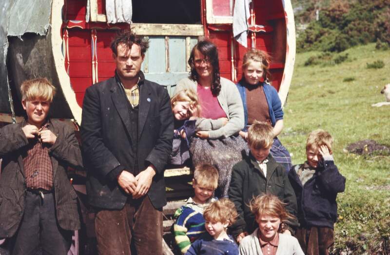 [Irish Traveller family outside their caravan]