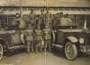 [Soldiers standing beside two armoured cars]