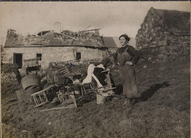 [Miss Brown outside cottage in Meelin, County Cork after a Black and Tan reprisal]