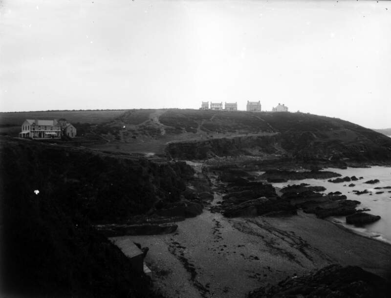 [View of a coastline, dotted with houses, in an unknown location]