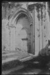 [Arched doorway with inscription over opening. Flat tombstones in foreground, possibly Corcomroe Abbey, North Clare.]