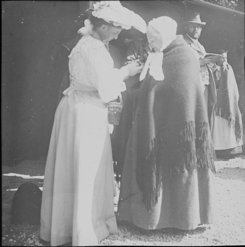 [Poultry show, G.L.D and Mrs Carroll 1904. Georgina Dillon presenting elderly woman "Mrs Carroll" with a rosette. Older woman wears a long woollen shawl.]