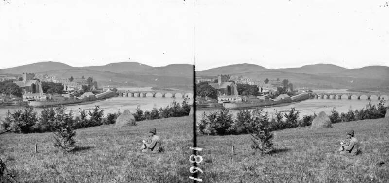 Long shot, town, river, bridge, seated person in field in foreground, hills in background, Killaloe, Co. Clare