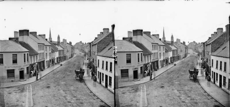 Street showing a cart, people, and shops, with a domed clock tower in the far background, Lisburn, Co. Antrim