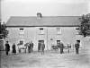 House and family standing about : commissioned by Father Phelan, Mooncoin, Co. Kilkenny