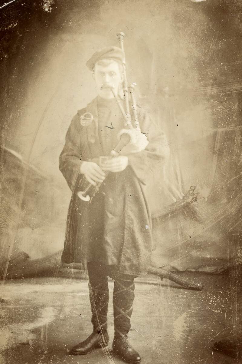 [Éamonn Ceannt, full-length, facing front portrait, wearing traditional dress, playing the pipes]