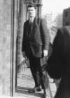 [Michael Collins, full-length facing right portrait, with moustache, wearing suit and tie, standing on balcony]