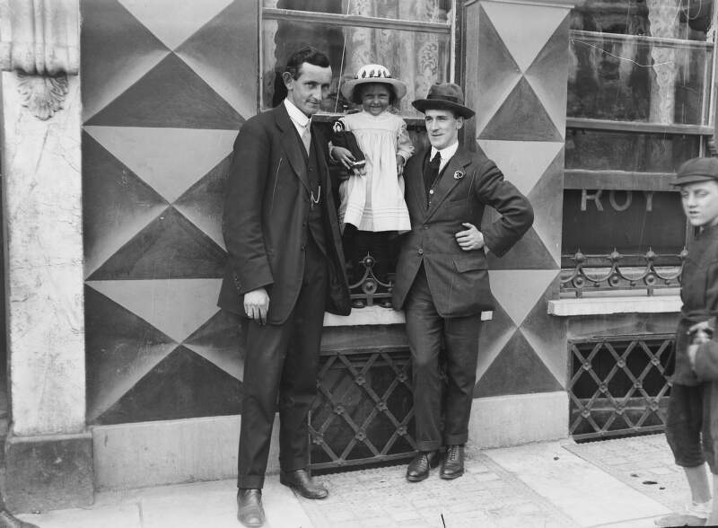 [Survivors of the Lusitania disaster, Cobh, Co. Cork : two men with young girl in hat and coat]