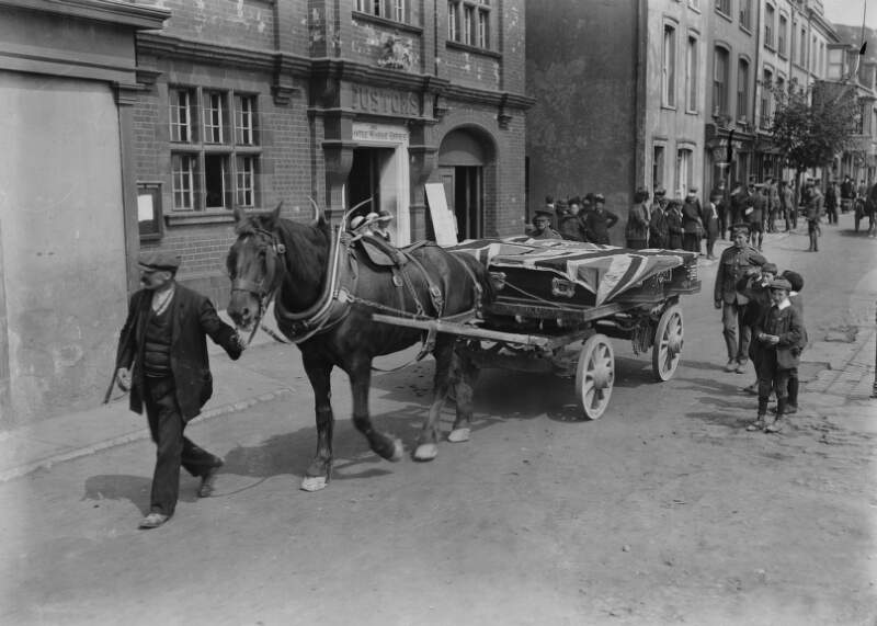 [Lusitania disaster, Cobh, Co. Cork : coffins draped in the British flag, being drawn by horse and cart]