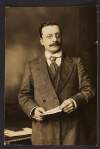 [Portrait photograph of Arthur Griffith standing with paper in his hands, half-length]