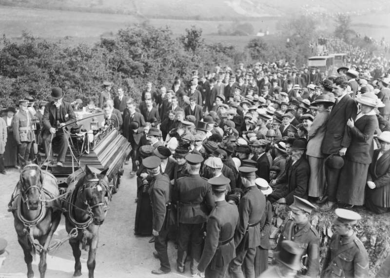 [Lusitania disaster, Cobh, Co. Cork : funeral procession for the victims of the disaster, with coffins drawn by horse and carriage and crowd gathered]