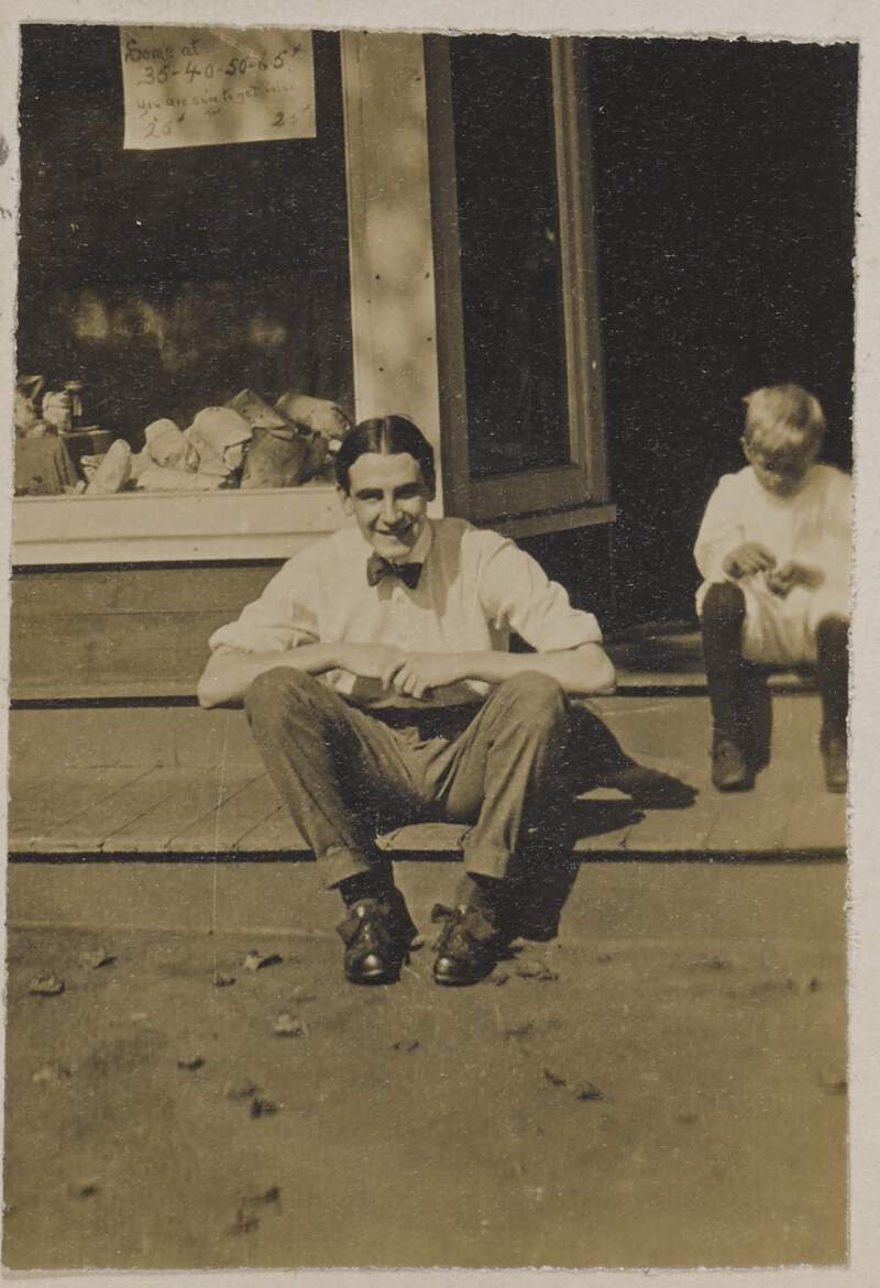 [Rex Ingram sitting on a step, looking at the camera with a child to the right of the image]