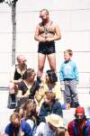 Young boy in crowd watching show beside men in leather. Dublin Lesbian and Gay Pride March