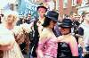 Close up of crowd featuring two women in pink and man in period drag. Dublin Lesbian and Gay Pride March