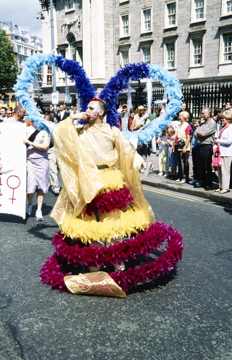 Eddie in gold drag with hooped feather boa skirt Dublin Lesbian and Gay Pride March
