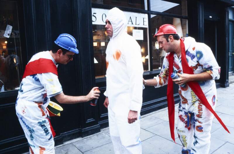 Two men spray painting another in white boiler suit Pre-Dublin Lesbian and Gay Pride March breakfast at Outhouse