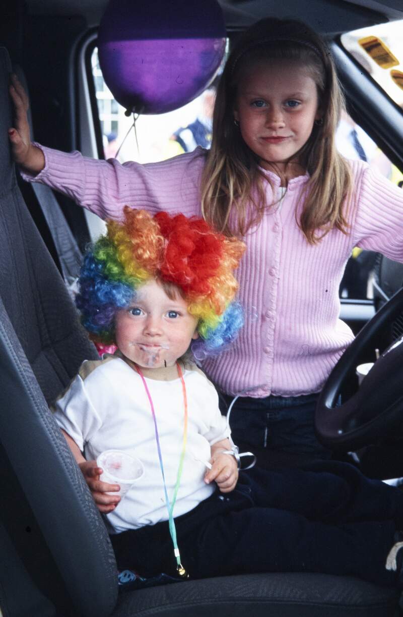 Young girl with toddler wearing rainbow wig in cab of a parade float Dublin Lesbian and Gay Pride March