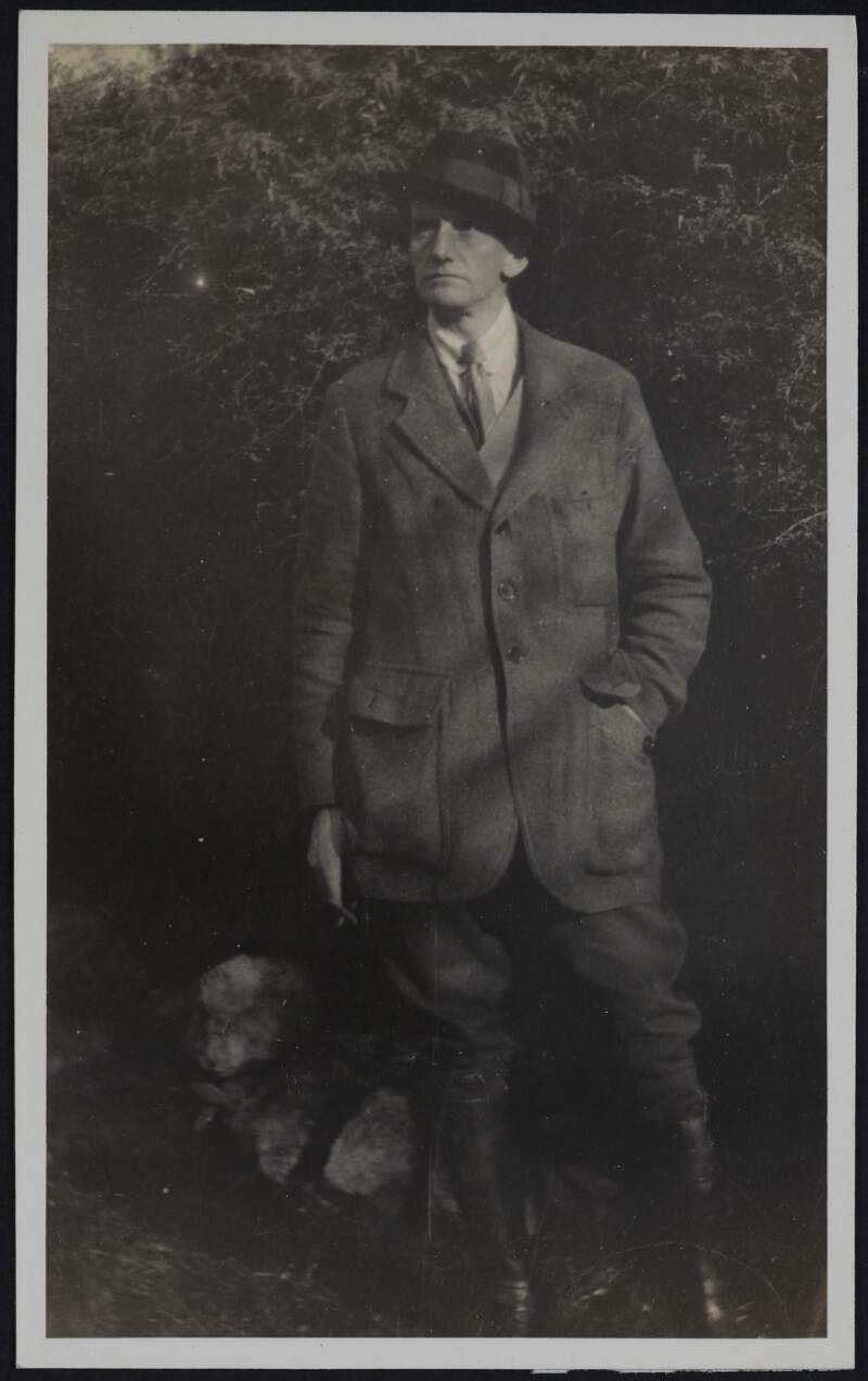 [Man standing with one hand in jacket pocket, full length portrait]
